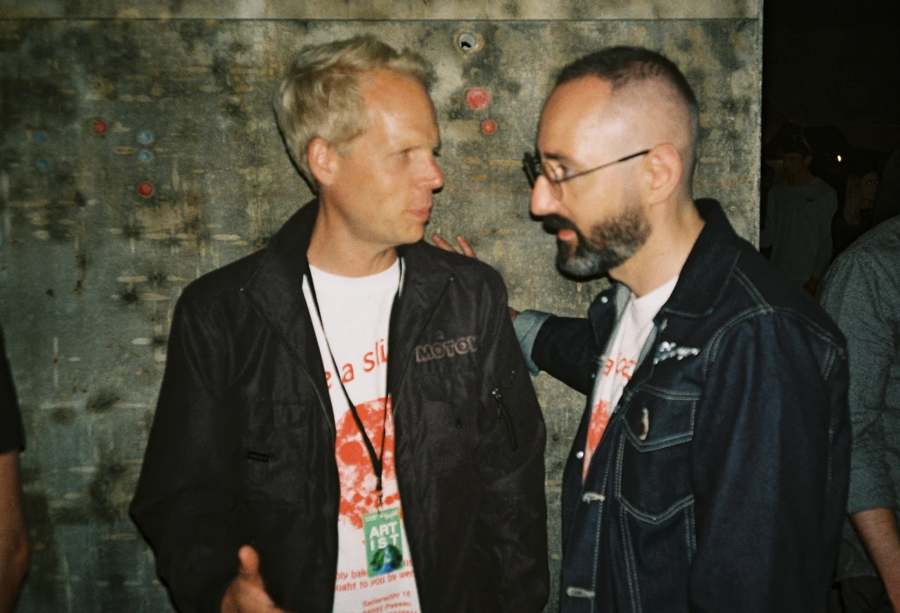 Zwei Männer im Gespräch backstage bei einem Konzert.