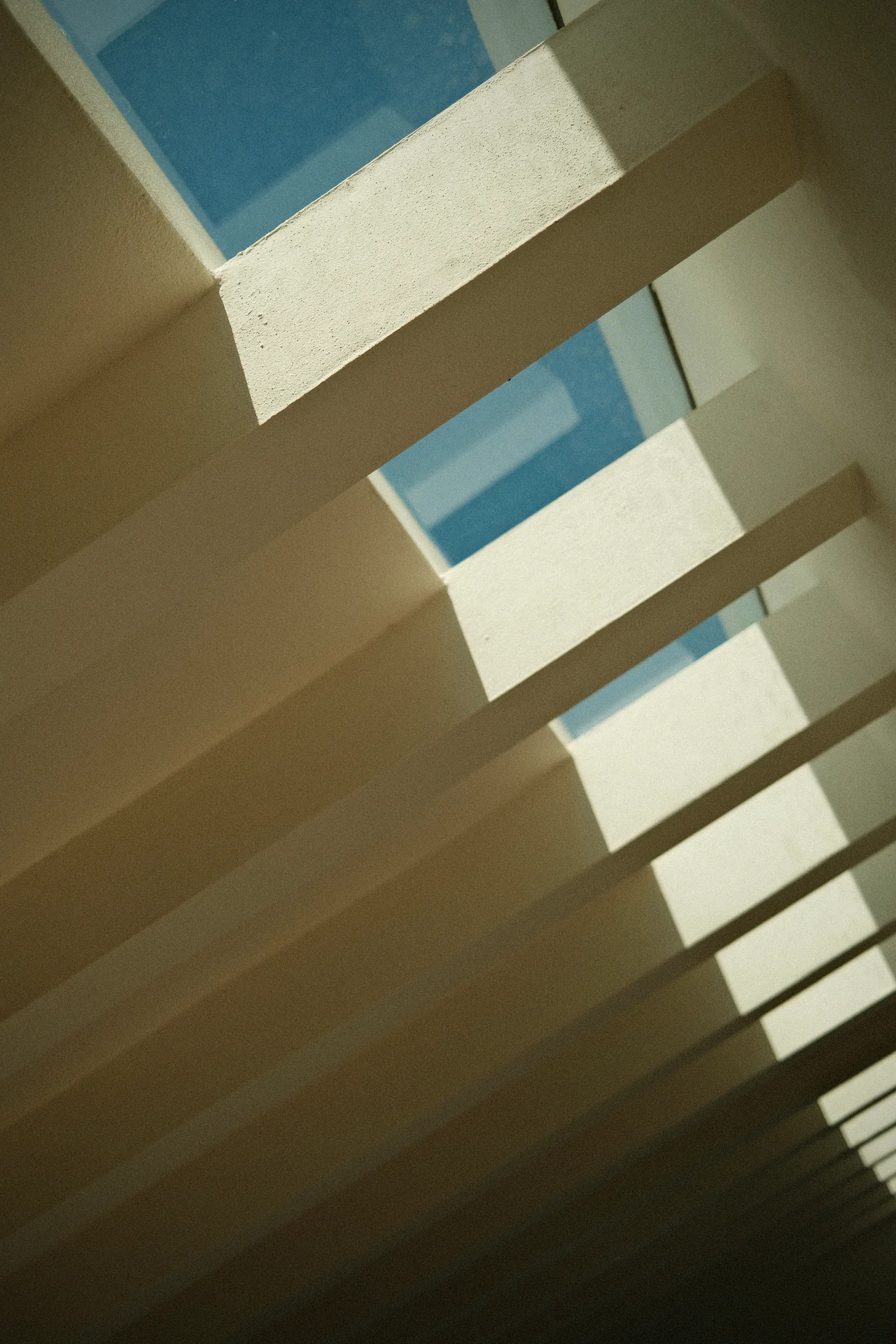 Helle Balken und ihre Schatten vor blauem Himmel.