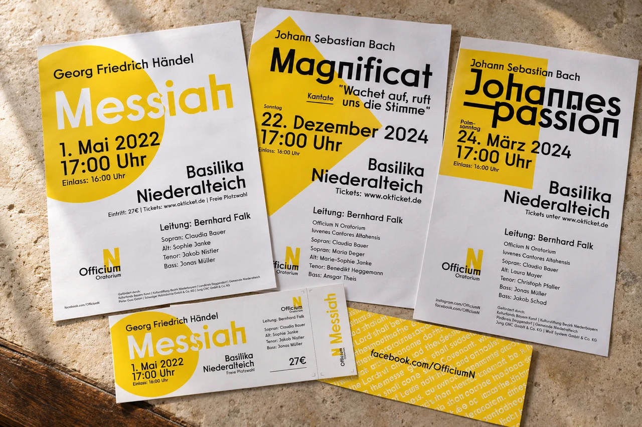 KI-Mockup der Plakate und Eintrittskarten für Officium N auf warmem Kalkstein mit einem schmalen Holzrand.